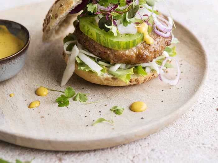 Broodje met een Premium kalkoenburger, frisse groentjes en mosterdsaus